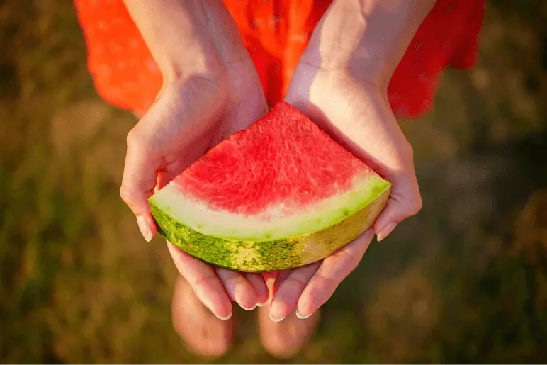 Watermelon being held.